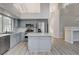 Elegant kitchen featuring gray cabinets, stainless appliances, a center island, and adjacent staircase at 1700 Wandering Winds Way, Las Vegas, NV 89128