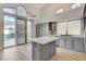 Stylish kitchen with gray cabinetry, quartz countertops, and direct access to the outdoor pool area at 1700 Wandering Winds Way, Las Vegas, NV 89128