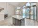 Open kitchen with quartz countertops, gray cabinets, a center island, and sliding glass door access at 1700 Wandering Winds Way, Las Vegas, NV 89128