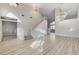 Open-concept living room featuring light wood floors, modern staircase, and lots of natural light at 1700 Wandering Winds Way, Las Vegas, NV 89128
