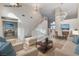 Bright, virtually staged living room with vaulted ceilings and staircase at 1700 Wandering Winds Way, Las Vegas, NV 89128