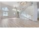Spacious living room featuring light wood floors, lots of natural light, and staircase with white railings at 1700 Wandering Winds Way, Las Vegas, NV 89128