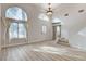 Spacious living room featuring light wood floors and a large arched window with lots of natural light at 1700 Wandering Winds Way, Las Vegas, NV 89128