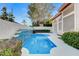 Private backyard pool with waterfall, surrounded by lush landscaping provides a tranquil retreat at 1700 Wandering Winds Way, Las Vegas, NV 89128