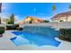 Beautiful pool with blue tile waterfall feature and well-maintained landscaping at 1700 Wandering Winds Way, Las Vegas, NV 89128