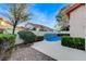 Relaxing backyard pool with custom waterfall feature and green landscaping creating a private oasis at 1700 Wandering Winds Way, Las Vegas, NV 89128