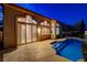 Relaxing backyard area with a refreshing pool, stylish tile accents, and beautiful lighting at 1700 Wandering Winds Way, Las Vegas, NV 89128