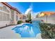 Refreshing backyard pool with waterfall surrounded by greenery, perfect for outdoor relaxation at 1700 Wandering Winds Way, Las Vegas, NV 89128