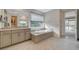 Bathroom with soaking tub, gray tiled floors, and a large window with a shade at 195 Cactus Sunrise St, Las Vegas, NV 89138