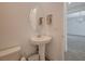 Powder room with pedestal sink, round mirror, and tiled floors at 195 Cactus Sunrise St, Las Vegas, NV 89138