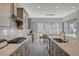 Bright kitchen featuring an island with sink, gray cabinets, gas cooktop, and quartz countertops at 195 Cactus Sunrise St, Las Vegas, NV 89138