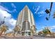 Modern high-rise condo building featuring multiple stories with balconies and palm tree landscaping at 200 Hoover Ave # 1210, Las Vegas, NV 89101