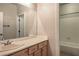 Bathroom featuring a light wood vanity, large mirror, and combined shower and tub at 2020 Sinfonia Ave, Henderson, NV 89052
