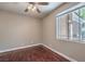 Cozy bedroom featuring hardwood floors, neutral walls, ceiling fan, and a bright window at 2020 Sinfonia Ave, Henderson, NV 89052