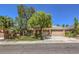 Well-maintained single-Gathering home with a lush green lawn, mature trees, and a two-car garage at 2020 Sinfonia Ave, Henderson, NV 89052