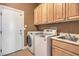 Bright laundry room features a modern washer and dryer, cabinets, and utility sink at 2020 Sinfonia Ave, Henderson, NV 89052
