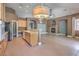 Open-concept living space with tan tile floors, wood cabinets, stainless appliances, and dining area at 2020 Sinfonia Ave, Henderson, NV 89052
