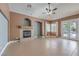 Spacious living room with fireplace, ceiling fan, tile flooring and a glass door leading to the back yard at 2020 Sinfonia Ave, Henderson, NV 89052