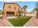 Well maintained backyard featuring a small patch of grass, rockscape, and palm trees at 2199 Timescape Ct, Las Vegas, NV 89123