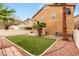 Landscaped backyard with a small patch of grass, rockscape, and palm trees at 2199 Timescape Ct, Las Vegas, NV 89123