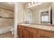 Bright bathroom boasts granite counters, wood cabinets, tile floors, and a tiled bath and shower at 2199 Timescape Ct, Las Vegas, NV 89123