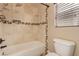 This bathroom features tiled walls and floors with a shower and tub combination at 2199 Timescape Ct, Las Vegas, NV 89123