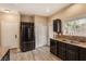 Modern kitchen with stainless steel appliances, dark cabinets and a double-door fridge at 2199 Timescape Ct, Las Vegas, NV 89123
