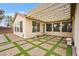 Inviting covered back patio with decorative string lights and artful brick and turf paver design at 2295 Aria Dr, Henderson, NV 89052
