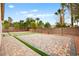 Spacious backyard with desert landscaping and decorative brick and turf paver design at 2295 Aria Dr, Henderson, NV 89052