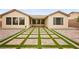 A large backyard with desert landscaping, brick pavers, and covered patio at 2295 Aria Dr, Henderson, NV 89052