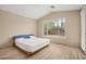 Cozy bedroom featuring neutral tones, a large window, and wood-style floors for a relaxing retreat at 2295 Aria Dr, Henderson, NV 89052