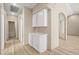 Neutral-toned hallway with storage cabinets and wood-look tile flooring leading to various rooms at 2295 Aria Dr, Henderson, NV 89052