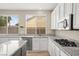 Bright kitchen features stainless steel appliances, white cabinets, and granite countertops, perfect for cooking and entertaining at 2295 Aria Dr, Henderson, NV 89052