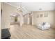 Bright open living room featuring wood floors, a chandelier, and an adjacent room at 2295 Aria Dr, Henderson, NV 89052