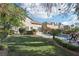 Expansive backyard with a pool, lush lawn, mature trees, and lounge chairs, perfect for outdoor entertaining at 2323 Carinth Way, Henderson, NV 89074