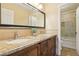 Well-lit bathroom with granite counters, double sinks, and tile-surround shower at 2323 Carinth Way, Henderson, NV 89074