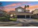 Charming two-story home with a three-car garage, manicured lawn, and a beautiful sunset backdrop at 2323 Carinth Way, Henderson, NV 89074