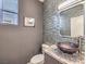 Contemporary powder room boasts a granite countertop, unique glass vessel sink, and modern fixtures at 251 S Green Valley Pkwy # 3412, Henderson, NV 89012