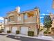 Exterior view of a multi-level townhome featuring garages, balconies, and manicured landscaping at 251 S Green Valley Pkwy # 3412, Henderson, NV 89012
