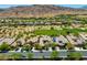 Aerial view of a luxury home with desert landscaping and a neighborhood golf course on a clear day at 2623 Turtle Head Peak Dr, Las Vegas, NV 89135