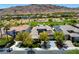 An aerial view of a neighborhood featuring desert landscaping, mature trees, and a nearby golf course at 2623 Turtle Head Peak Dr, Las Vegas, NV 89135