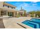Gorgeous backyard with a luxurious pool, spa, and outdoor kitchen area with lush green plants around at 2623 Turtle Head Peak Dr, Las Vegas, NV 89135