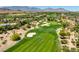 Scenic view of a lush green golf course surrounded by desert landscape and luxury homes at 2623 Turtle Head Peak Dr, Las Vegas, NV 89135