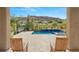 Backyard pool area featuring a waterfall feature, desert landscaping, and patio seating with mountain views at 2623 Turtle Head Peak Dr, Las Vegas, NV 89135