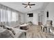 Cozy living room with hard surface floors, a ceiling fan, and a mounted TV for entertainment at 3305 Palomar St, North Las Vegas, NV 89030