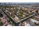 Overhead view of a residential area with tiled roofs, mature trees lining the streets, and a distant view of city buildings on the horizon at 3440 Pino Cir, Las Vegas, NV 89121