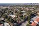 Expansive aerial view of a residential neighborhood featuring tree-lined streets and varied home styles with Las Vegas skyline in the distance at 3440 Pino Cir, Las Vegas, NV 89121