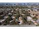 Wide aerial view of a neighborhood with a mix of housing, mature trees, and a glimpse of a blue pool, with the city skyline in the background at 3440 Pino Cir, Las Vegas, NV 89121