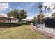 Spacious backyard with a fenced pool area, lush greenery, and a beautiful landscape at 3440 Pino Cir, Las Vegas, NV 89121