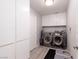 Convenient laundry room with modern washer and dryer units, ample storage, and tile flooring at 3440 Pino Cir, Las Vegas, NV 89121